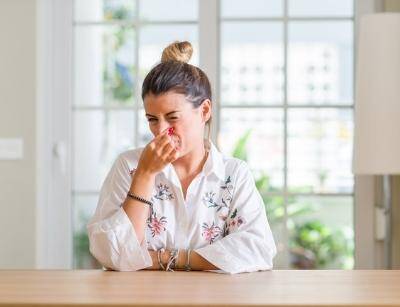 woman pinching her nose against bad smell